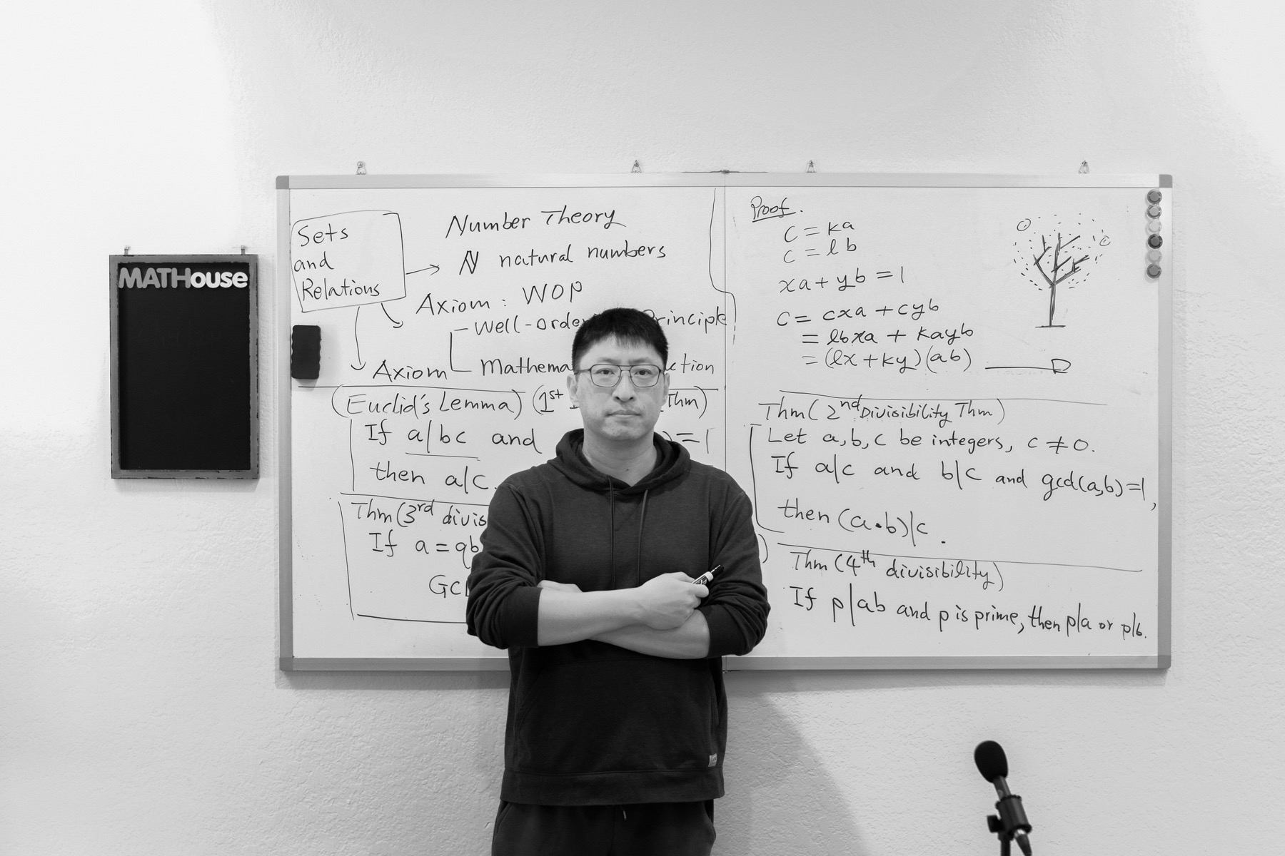 Philip Hu in the TMH classroom, standing before a whiteboard of number theory notes